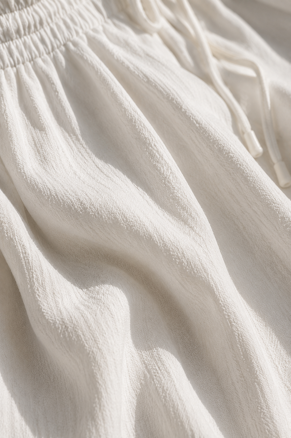 Detalle del tejido del pantalón Terra: crepé de textura arrugada y ligera con el cordón