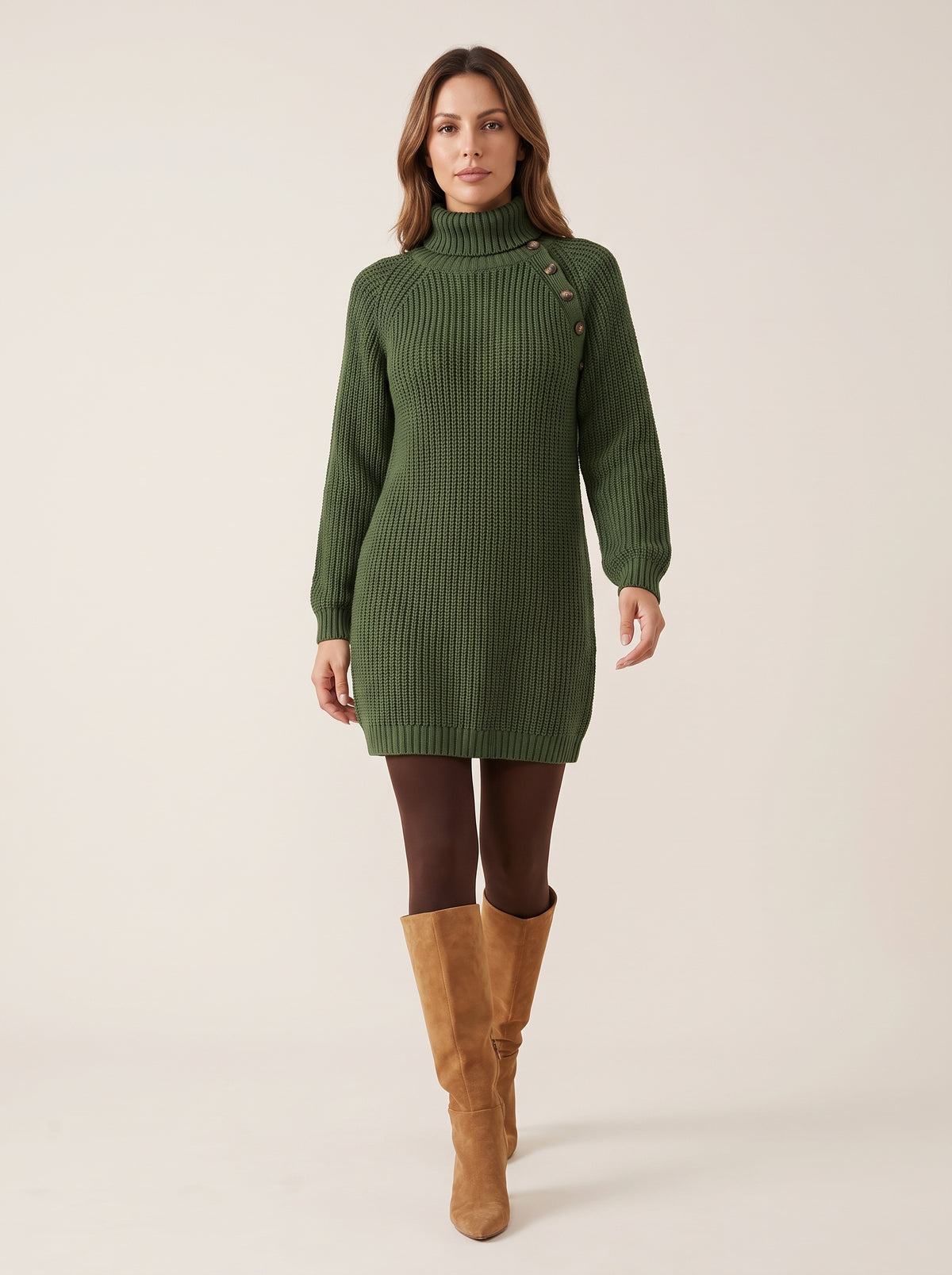 Modelo caminando con el vestido jersey Alba verde militar, medias marrones y botas camel