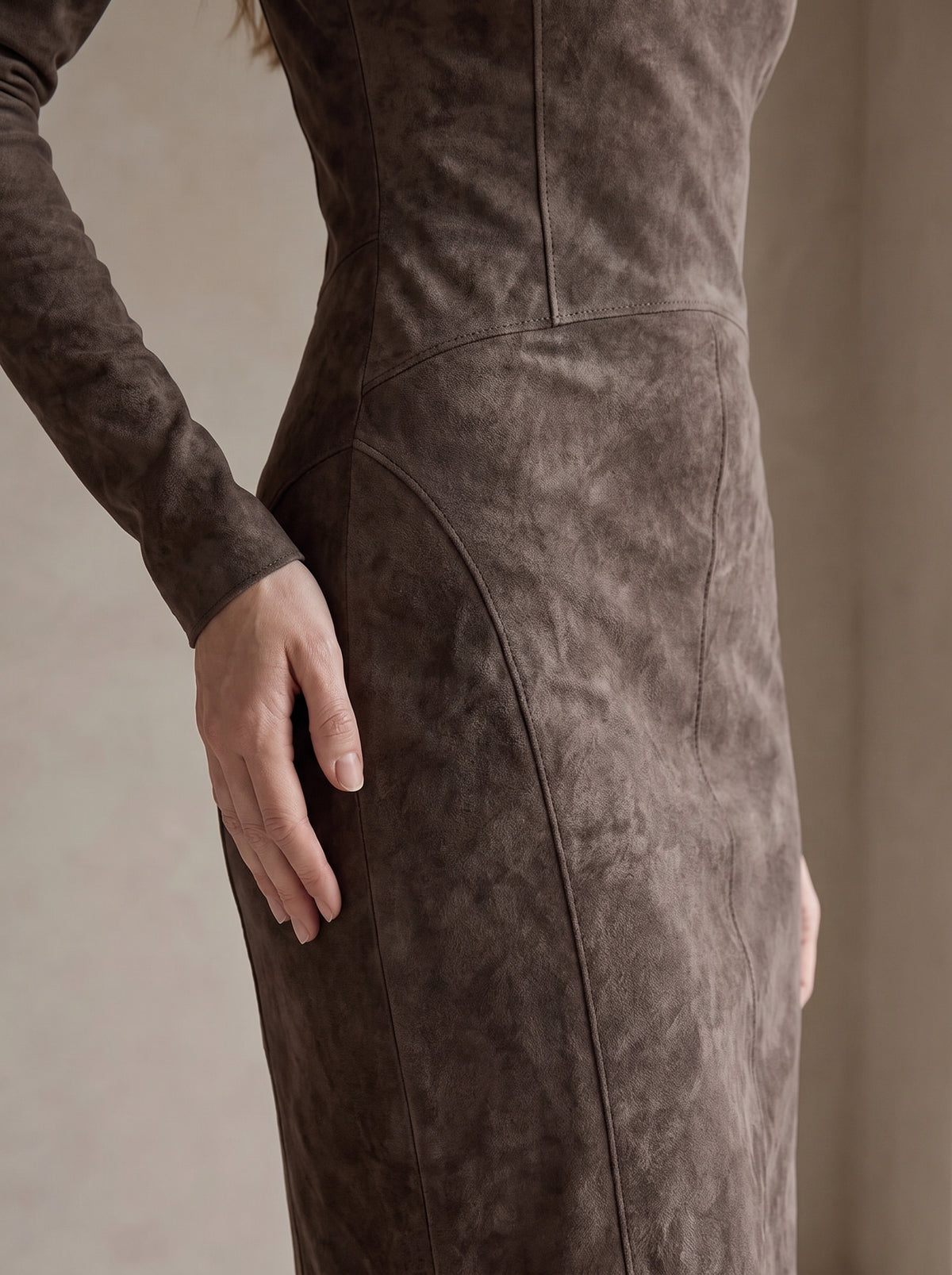 Detalle de la costura curva de la cadera y la textura efecto ante del vestido Elsa