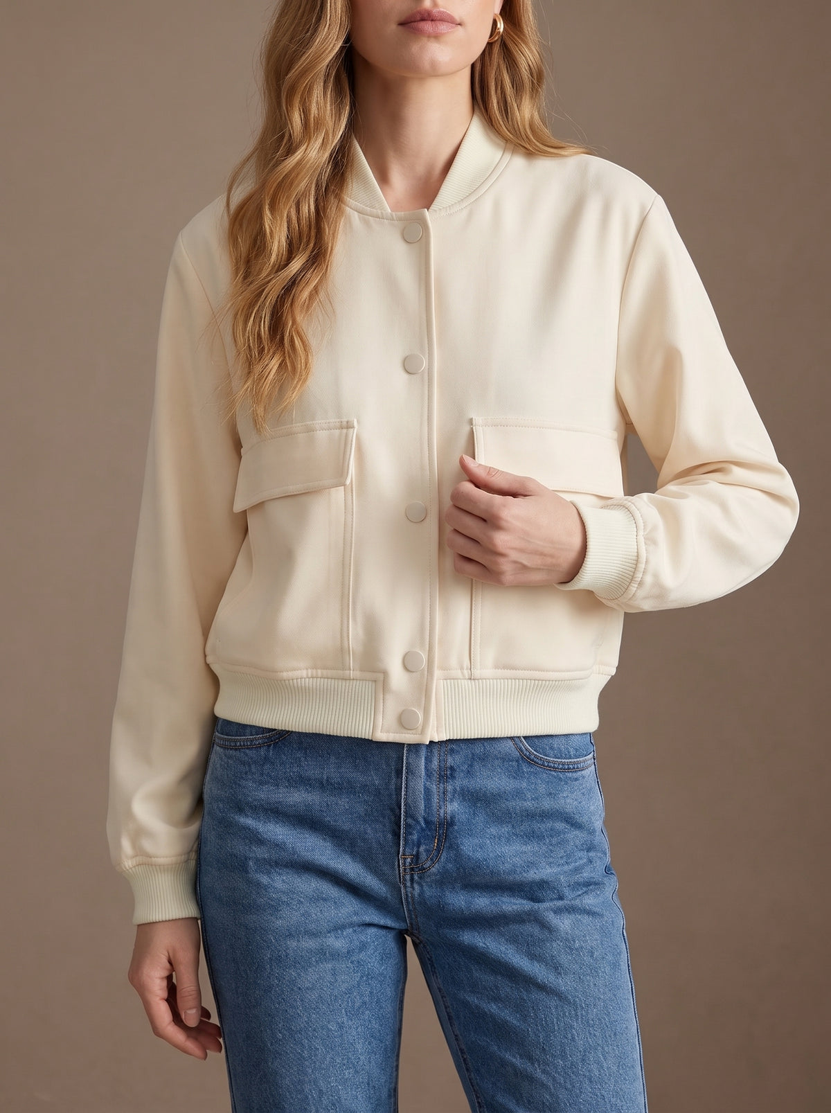 Chaqueta bomber Ariana en crema de cerca, con cierre de automáticos y bolsillos con solapa
